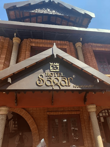 Hotel Sagar Kozhikode sign on facade with ornate architectural details.
